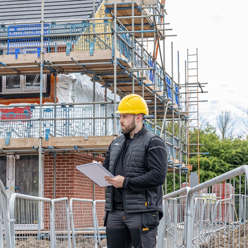 A black padded bodywarmer designed for use on construction sites and in industrial work environments.,