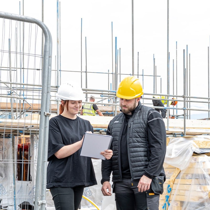 A black padded bodywarmer designed for use on construction sites and in industrial work environments.,