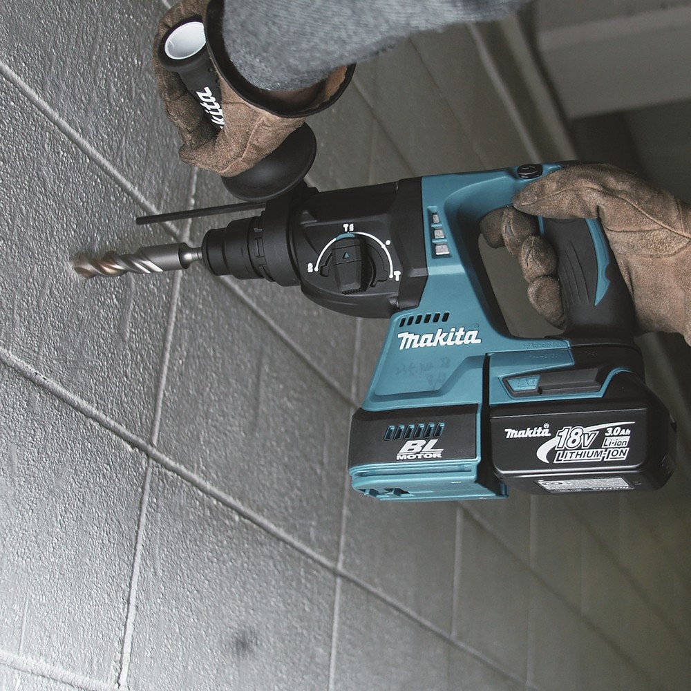 A teal and black Makita cordless combi drill with an 18V motor, a 13mm keyless chuck, and hammer, drill, and screwdriver modes.