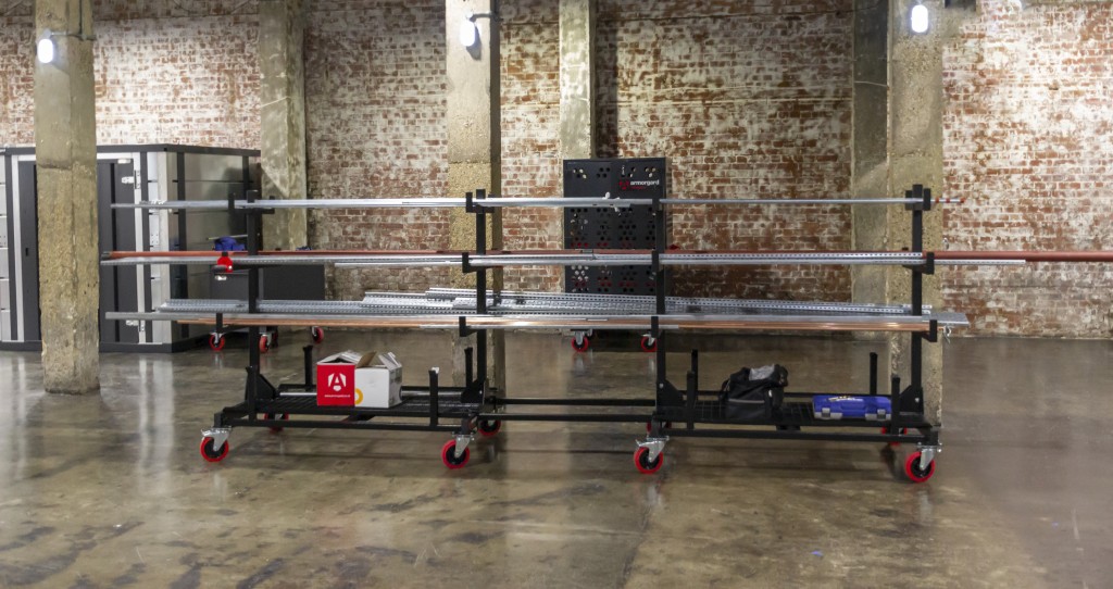 A steel metal shelving unit with adjustable shelf heights and a robust welded steel frame, for organised storage in workshops and site cabins.