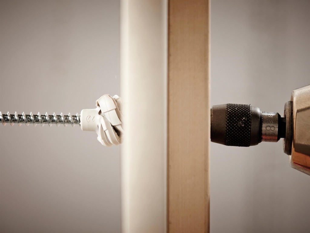 An orange and black Spit cordless power tool, with an ergonomic grip, designed for use on construction and maintenance tasks.