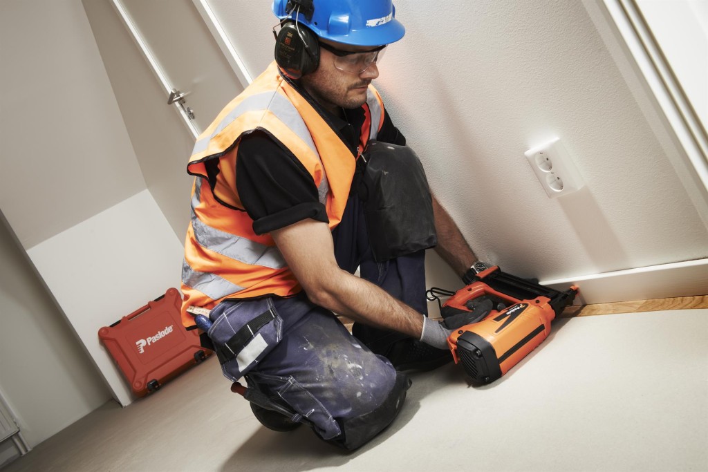 A Paslode cordless stapler with a magazine feed and safety tip, for fastening materials using heavy-duty staples.