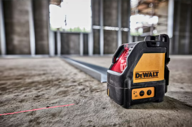 A yellow and black DEWALT self-levelling laser level projecting horizontal and vertical lines, for precision alignment and setting-out work.