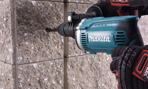 A teal and black Makita cordless drill driver with 110V a keyless chuck and variable-speed trigger, for drilling and screw driving.