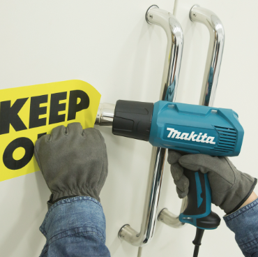 A teal and black Makita heat gun with dual temperature settings and a soft-grip handle, for shrinking, stripping, and bending.