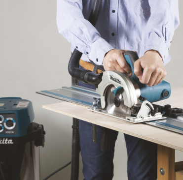 A teal and black Makita corded circular saw with a 110V motor, an adjustable bevel plate, and a blade guard, for ripping and cross-cutting timber.