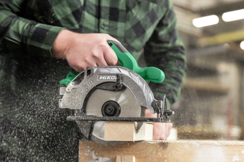A green and black HiKOKI cordless circular saw with a 18V motor, an adjustable bevel plate, and a blade guard, for ripping and cross-cutting timber.