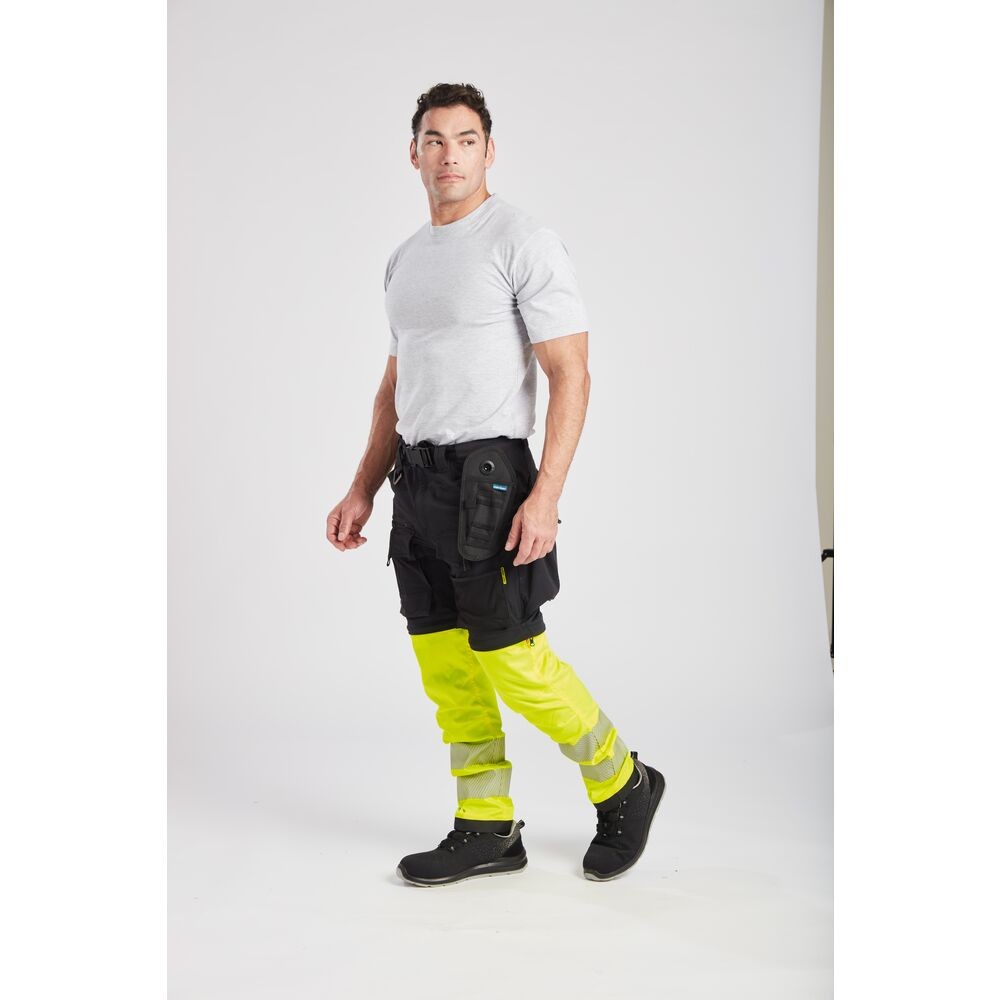 A pair of black work trousers designed for use on construction sites and in industrial work environments.,