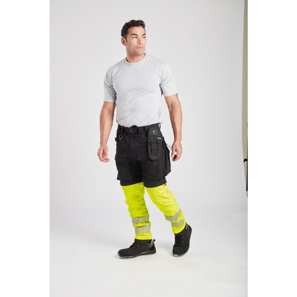 A pair of black work trousers designed for use on construction sites and in industrial work environments.,
