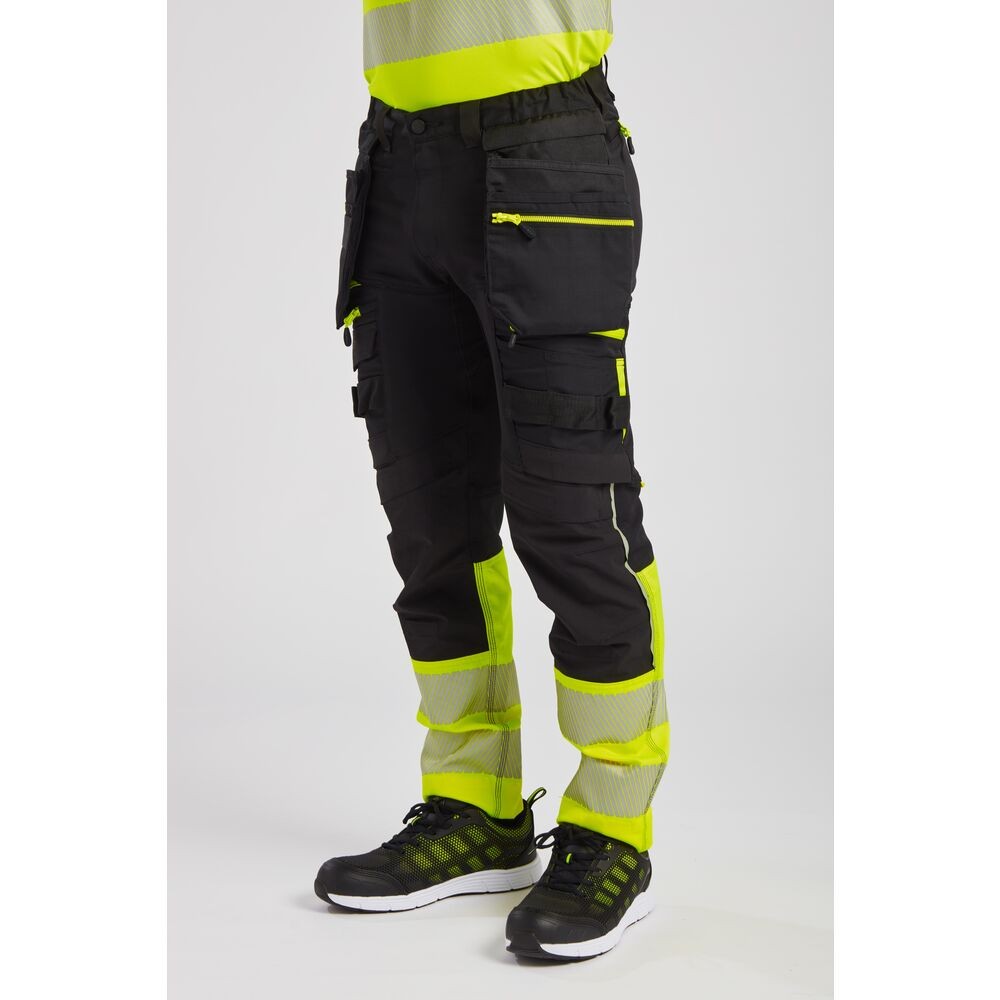 A pair of high-visibility yellow trousers featuring retroreflective tape panels, functional pockets, suitable for a wide range of outdoor and site work applications.