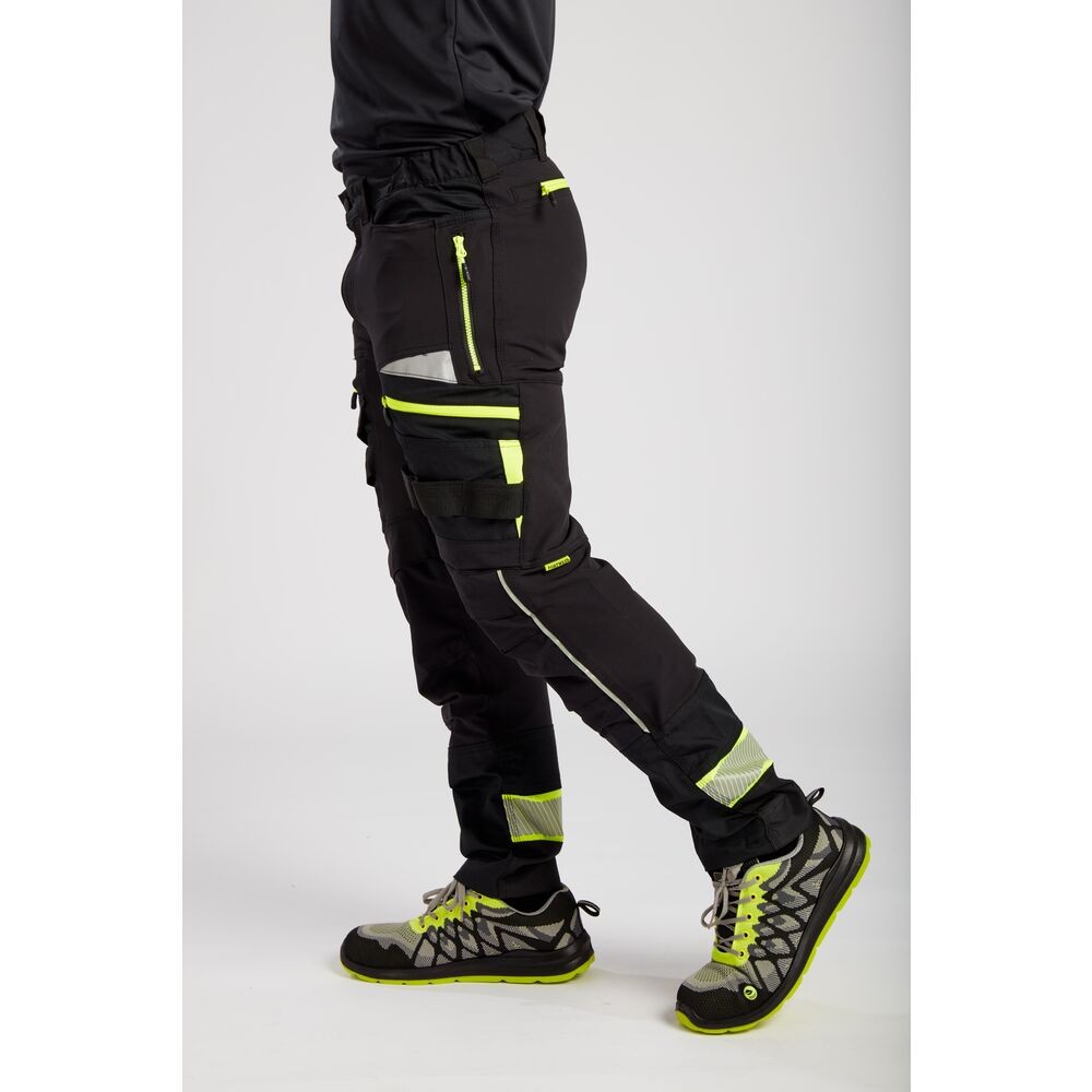 A pair of black work trousers designed for use on construction sites and in industrial work environments.,