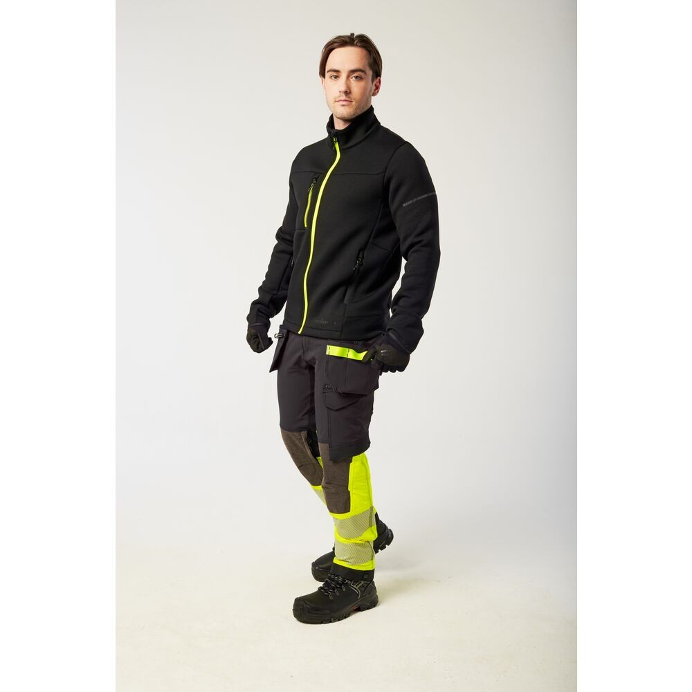 A black softshell jacket designed for use on construction sites and in industrial work environments.,