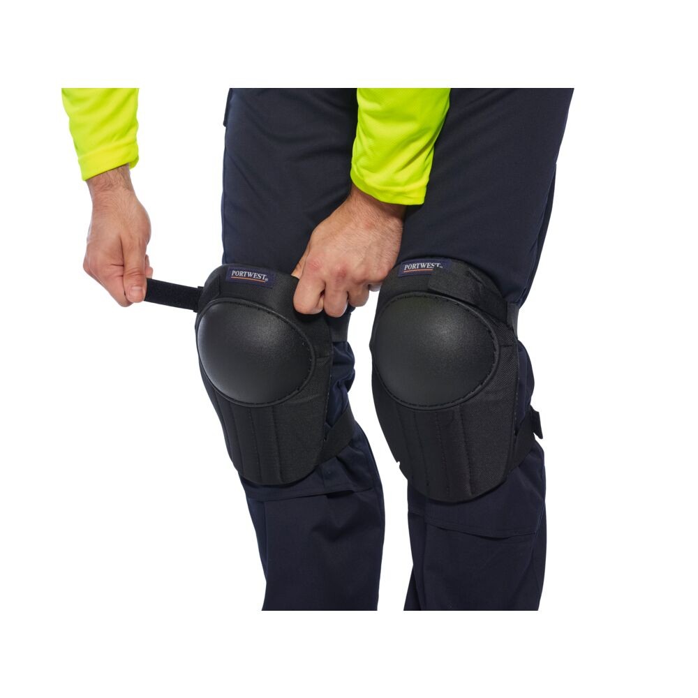 A pair of black foam-padded knee pads with adjustable straps, designed to protect the knees during kneeling work.