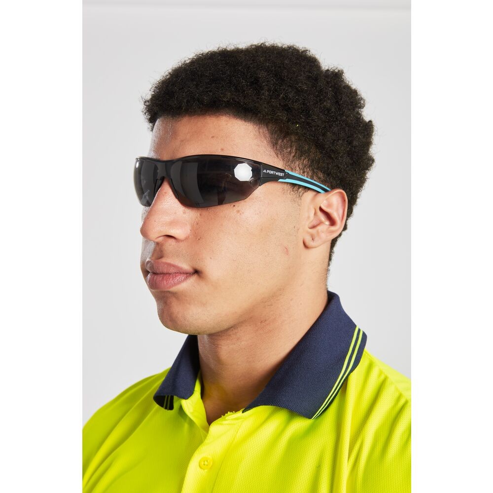 A pair of safety spectacles with clear impact-resistant lenses and adjustable side arms, for eye protection during site work.