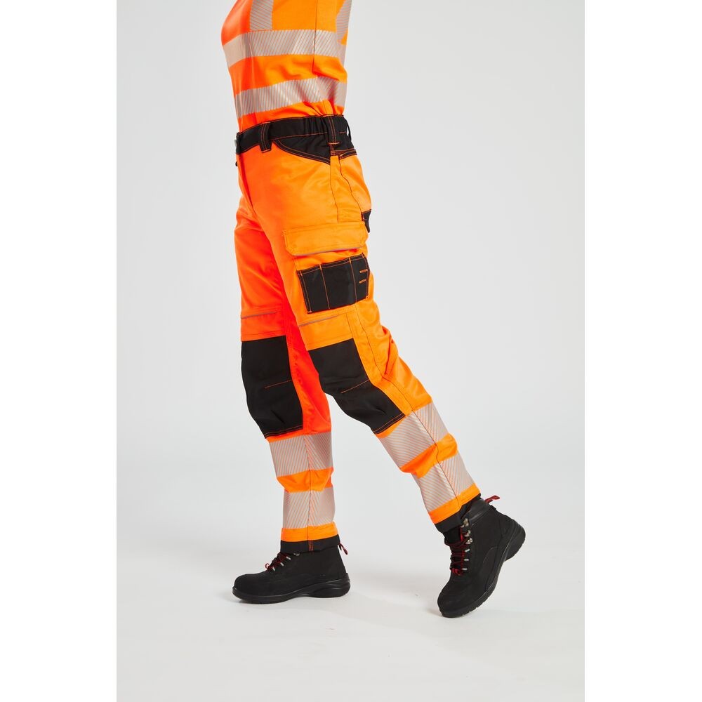 A pair of women's high-visibility orange trousers featuring retroreflective tape panels, stretch panels for ease of movement, suitable for a wide range of outdoor and site work applications.