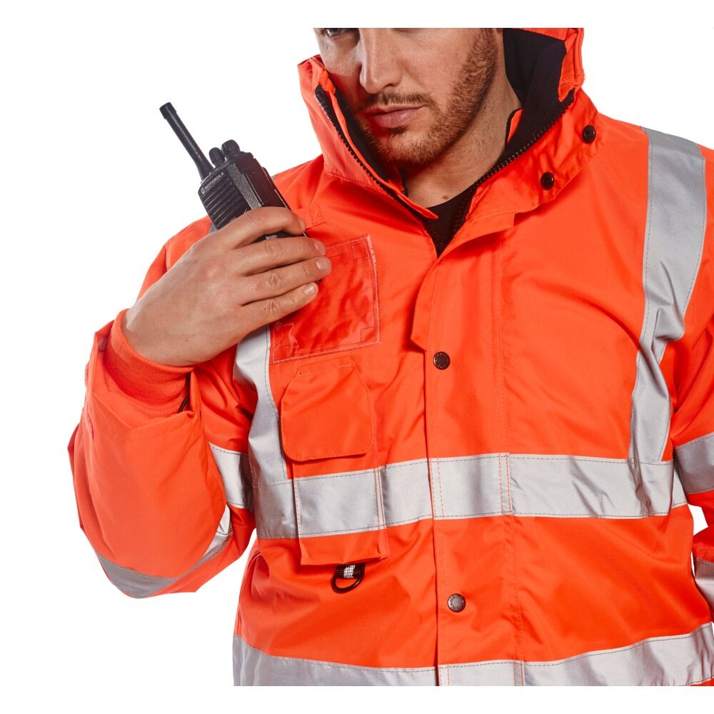 A high-visibility orange waterproof jacket featuring retroreflective tape panels, a breathable membrane, suitable for a wide range of outdoor and site work applications.