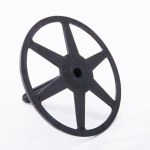 A black plastic circular object with five spokes radiating from a central hub, resembling a wheel, is standing upright on a white background.