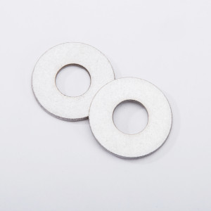 Two flat, round metal washers with central holes are lying on a white background, slightly overlapping each other.