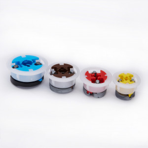 Four round plastic and metal objects of different sizes and colors (blue, brown, red, and yellow) are lined up side by side on a white background.