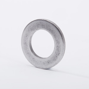 A metallic washer standing upright on a white surface, with a circular hole in the center and a slightly textured, silver-gray finish.
