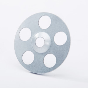 A round, flat metal disk with six evenly spaced circular holes and a central hole, placed upright on a white background.