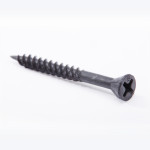 A close-up of a single black Phillips-head screw with a sharp tip, lying diagonally on a white background.