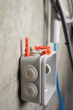 An orange and black Spit cordless power tool, with an ergonomic grip, designed for use on construction and maintenance tasks.