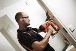 A Paslode cordless stapler with a magazine feed and safety tip, for fastening materials using heavy-duty staples.