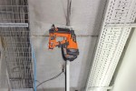 An orange and black Spit cordless power tool, with an ergonomic grip, designed for use on construction and maintenance tasks.