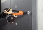 An orange and black Spit cordless power tool, with an ergonomic grip, designed for use on construction and maintenance tasks.