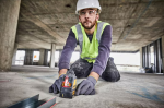 A yellow and black DEWALT self-levelling laser level projecting horizontal and vertical lines, for precision alignment and setting-out work.