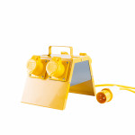 A yellow portable electrical power distribution box with two covered outlets and a carrying handle, connected to a yellow power cable ending in a round, orange and white plug, isolated on a white background.