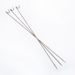 Four long, metal skewers with hooked ends are arranged in an overlapping X pattern on a white background.