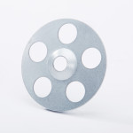 A round, flat metal disk with six evenly spaced circular holes and a central hole, placed upright on a white background.