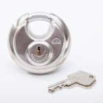 A round, stainless steel padlock with the brand name Squire engraved on it, shown next to its matching metal key on a white background.