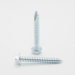 Two shiny metal screws with hexagonal heads are standing on a white surface; one screw is upright while the other lies flat in front of it.,