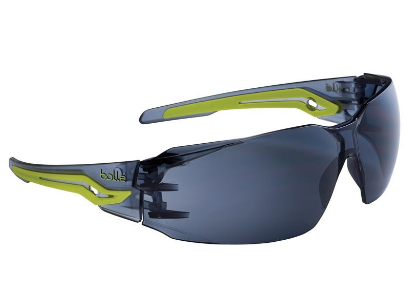 Sporty safety sunglasses with wraparound dark lenses and green-accented arms, featuring the bolle logo on the side.