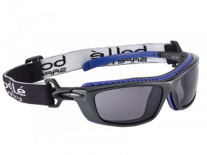 A pair of black and blue safety goggles with tinted lenses, a thick adjustable elastic strap, and side ventilation. The strap features the brand name Bollé Safety in white letters.