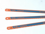 Three orange and blue hacksaw blades labeled with different teeth per inch: 32 TPI, 24 TPI, and 18 TPI, each measuring 12 inches (300 mm) in length, are arranged on a white background.