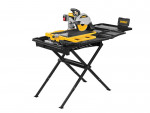 A DeWalt tile saw with a yellow and black design is mounted on a black foldable stand, featuring a sliding tray and water reservoir for wet cutting. The setup is isolated on a white background.