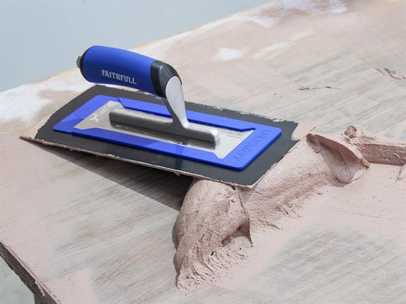 A Faithfull trowel with a polished steel blade and an ergonomic handle, for applying and finishing mortar, plaster, and adhesive.