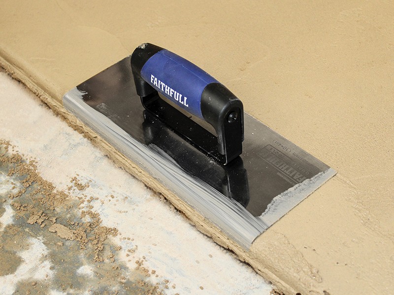 A Faithfull trowel with a polished steel blade and an ergonomic handle, for applying and finishing mortar, plaster, and adhesive.