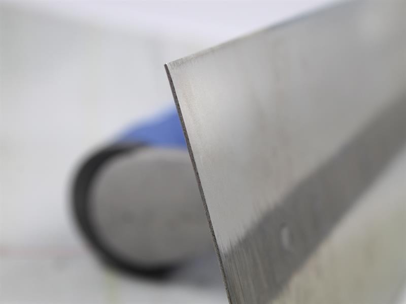 A Faithfull plasterer's finishing trowel with a thin, flexible steel blade and a turned wooden handle, for achieving smooth plaster surfaces.