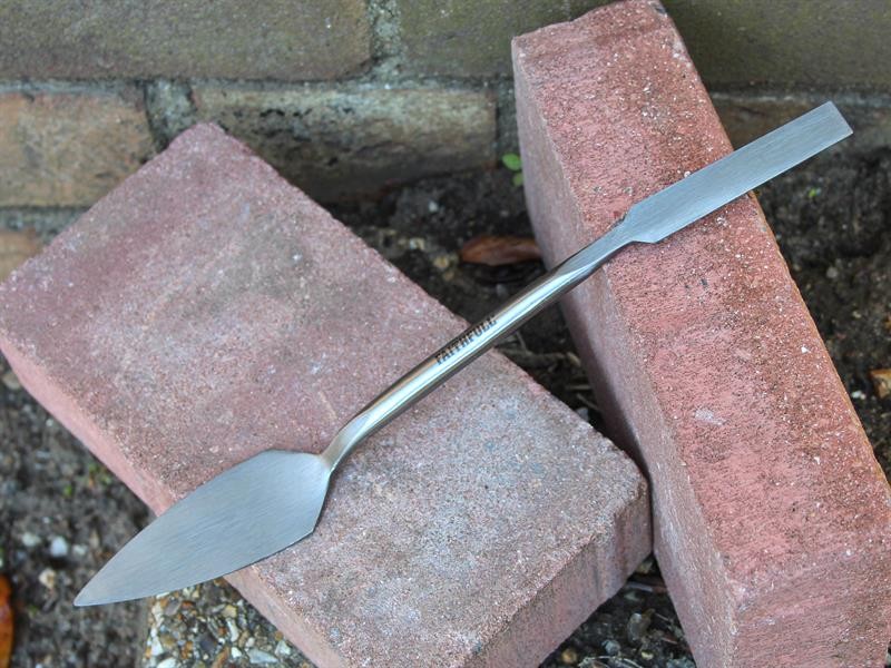 A Faithfull trowel with a polished steel blade and an ergonomic handle, for applying and finishing mortar, plaster, and adhesive.