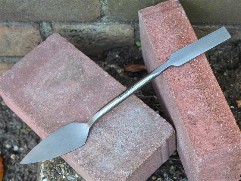 A Faithfull trowel with a polished steel blade and an ergonomic handle, for applying and finishing mortar, plaster, and adhesive.