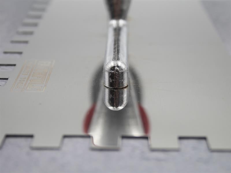 A Faithfull notched tile trowel with 10mm notches for combing adhesive on floors and walls, ensuring even coverage beneath tiles.