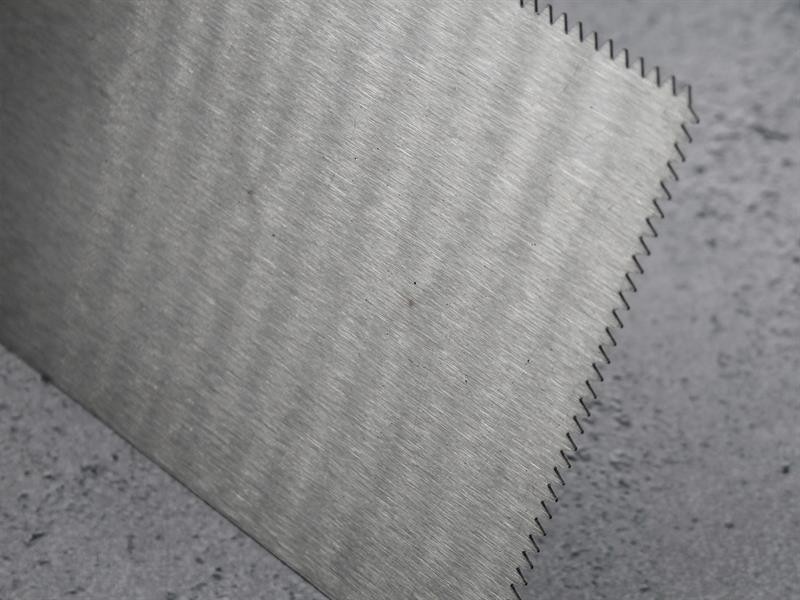 A Faithfull notched tile trowel with 3mm notches for combing adhesive on floors and walls, ensuring even coverage beneath tiles.