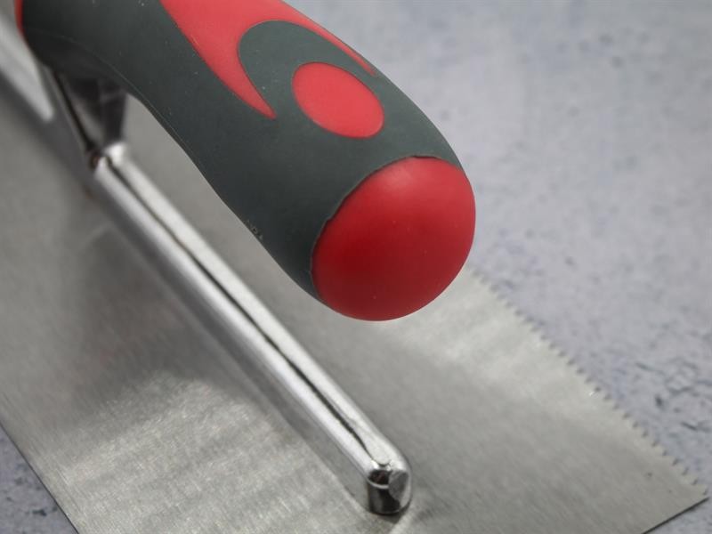 A Faithfull notched tile trowel with 3mm notches for combing adhesive on floors and walls, ensuring even coverage beneath tiles.