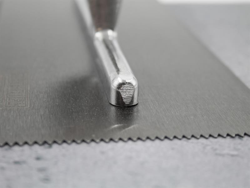 A Faithfull notched tile trowel with 3mm notches for combing adhesive on floors and walls, ensuring even coverage beneath tiles.