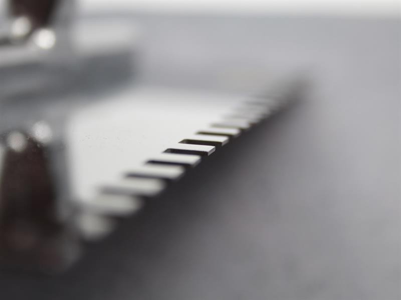 A Faithfull notched tile trowel with 6mm notches for combing adhesive on floors and walls, ensuring even coverage beneath tiles.